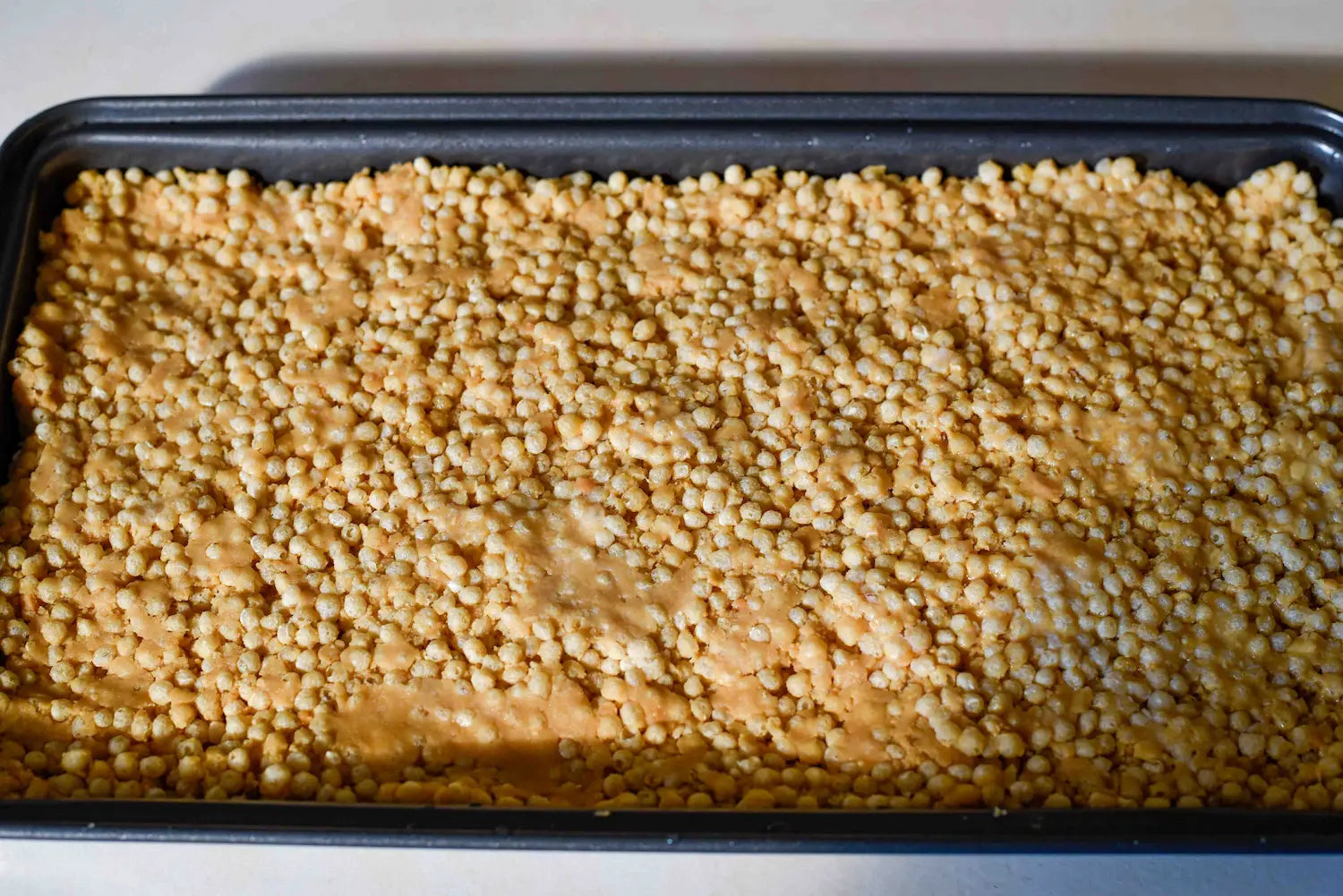 Pressing Roam Protein mix into baking tray before setting